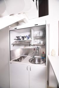 - une cuisine avec des placards blancs et un évier dans l'établissement Entechnos Living, à Skiathos Chora