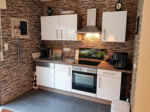a kitchen with white cabinets and a sink at Ferienwohnung Rheinzeit beim Toni mit Terrasse und Balkon mit Rheinblick in Boppard