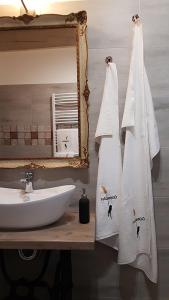 a bathroom with towels and a sink and a mirror at Nádirigó Apartman Balatonberény in Balatonberény