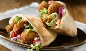 two fried meatballs in a wrap on a plate at Bedouin family house in Wadi Musa