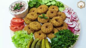 a plate of food with onion rings and vegetables at Bedouin family house in Wadi Musa