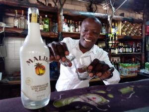 a man holding a glass next to a bottle of alcohol at Kivu Resort in Nakuru