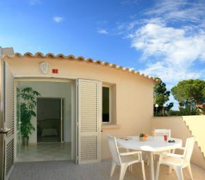 eine Terrasse mit einem weißen Tisch und Stühlen und einem Haus in der Unterkunft Résidence San Pellegrino in Folelli + 68 Fotos