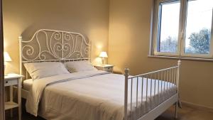 1 dormitorio con 1 cama blanca y 2 ventanas en Tra gli ulivi, en Putignano