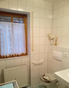 a white bathroom with a toilet and a window at Apartment Barbara in Regensburg