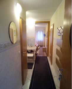 un pasillo con una habitación con una mesa y un espejo en Apartment Barbara en Regensburg