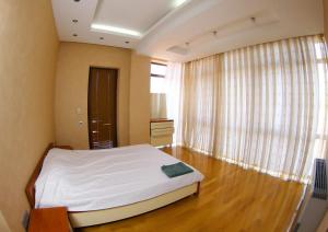 een slaapkamer met een bed en een groot raam bij BAKU CITY CENTRE APARTMENT in Baku