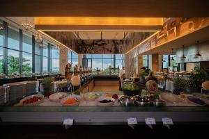 パタヤ・ノースにあるTsix5 Phenomenal Hotel Pattayaのレストランで食べ物が並べられたビュッフェライン
