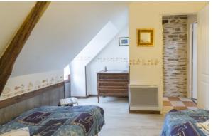 a bedroom with two beds and a dresser in a room at Gîte Blé Noir Le Clos du Tay in La Gacilly
