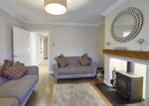 sala de estar con sofá y chimenea en Host & Stay - Lowcross Cottage, en Guisborough