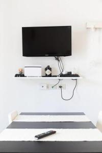 a white room with a television and a remote control at Ostuni D. Home in Ostuni