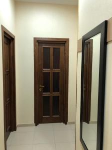 a hallway with a wooden door and a mirror at Freedom Square Apartment in Tbilisi City