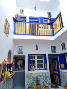 a living room with a blue and yellow staircase at berber hostel in Essaouira