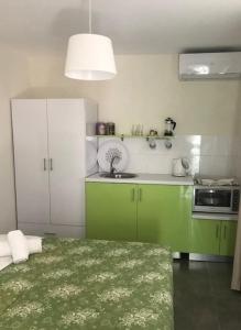 una cucina con armadi verdi e bianchi e un lavandino di Filippos Resort II by Karidi a Vourvourou