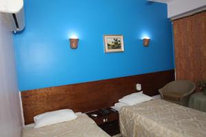 a bedroom with a blue wall and a blue bed at Rezeiky Hotel & Camp in Luxor