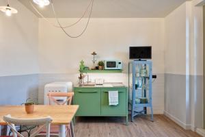 una cucina con mobile verde e tavolo di La casa del Mercato - Design Apartment a Torino