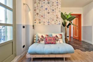 una camera con letto blu e cuscini di La casa del Mercato - Design Apartment a Torino
