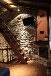 pared de piedra con escalera y TV en El Refugio de Luena en San Miguel de Luena