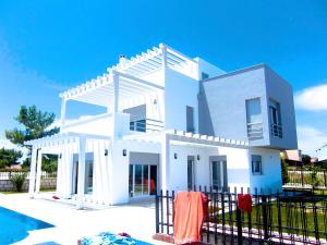 a white house with a pool in front of it at Luxury Villa with amazing view, Cesme in Cesme