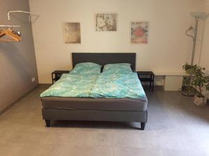 - une chambre dotée d'un lit avec des draps bleus dans l'établissement Gemütliches Apartment nahe Porsche, à Weissach