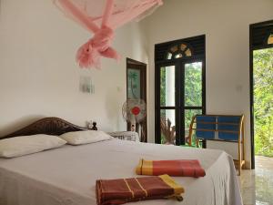 A bed or beds in a room at Sigiriya River Side Villa