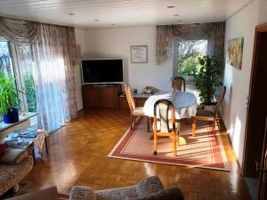 a living room with a table and chairs and a television at Ferienwohnung am Wald - Nähe Funpark in Zirndorf