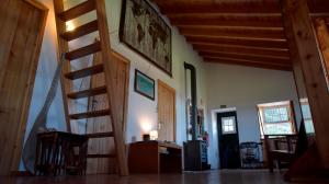 a living room with wooden stairs and a stair case at Caldeira Guesthouse in Fajã da Caldeira de Santo Cristo