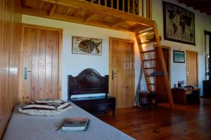 a bedroom with a bed and a wooden staircase at Caldeira Guesthouse in Fajã da Caldeira de Santo Cristo