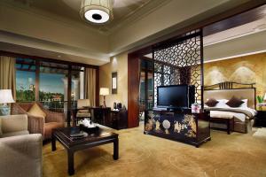 a living room with a bed and a couch and a tv at Hotel Shanghai Sheshan Oriental - Handwritten Collection in Songjiang