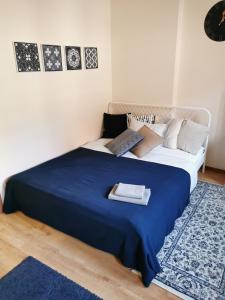 1 dormitorio con 1 cama grande con manta azul en Apartament Ducha NO'7, en Toruń