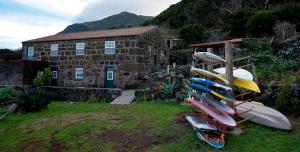 a pile of surfboards sitting in front of a house at Caldeira Guesthouse in Fajã da Caldeira de Santo Cristo