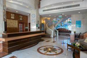 a lobby with a staircase in a building at Ramada by Wyndham Beach Hotel Ajman in Ajman 