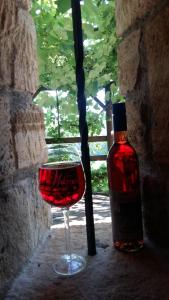 ein Glas Wein neben einer Flasche Wein in der Unterkunft Kellerstöckl am Rosenberg in Straden