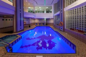 a large indoor swimming pool in a building at Ramada by Wyndham Beach Hotel Ajman in Ajman 