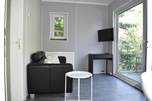 un salon avec un canapé noir et une table dans l'établissement Den Laage hof, à Heusden