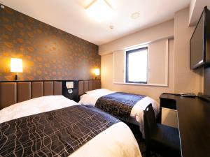 a hotel room with two beds and a television at APA Hotel Aomorieki-higashi in Aomori