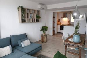 un soggiorno con divano blu e tavolo di Javea luxury apartment 50m from Arenal sandy beach a Jávea