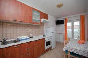 a kitchen with wooden cabinets and a sink and a table at Holiday S&M in Lopar