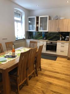 a kitchen with a wooden table with chairs and a dining room at 'Ferienhaus Mosel' mit kostenfreien ÖPNV-Ticket in Ürzig
