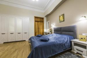 a bedroom with a blue bed and white cabinets at Kiev Lodging in Kyiv