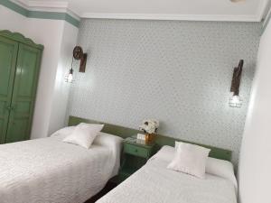 a hotel room with two beds and two lamps at Don Diego in Ávila