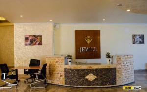 um lobby com um balcão com cadeiras e um sinal na parede em Jewel Matrouh Hotel em Marsa Matruh