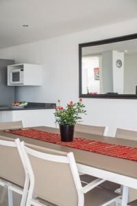 a table with two white chairs and a plant on it at Funkey Villas Cape Town in Cape Town