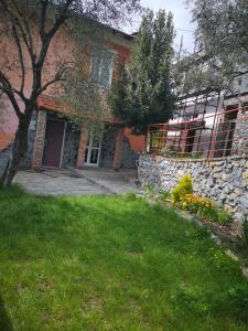 una casa in mattoni con un muro di pietra e un cortile di Relax a Sesta Godano