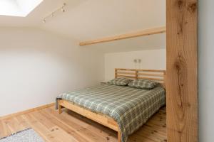 a bedroom with a bed with a wooden frame at La Cabane Loft cosy au cœur de Libourne à deux pas de la gare et proche Saint-Emilion in Libourne