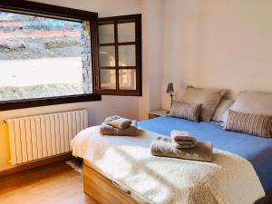 1 dormitorio con 1 cama con toallas en Cases de Canillo-Casa Sant Serni en Canillo