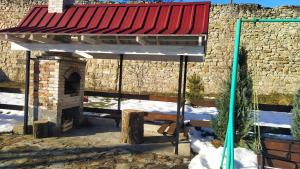 a building with a red roof in the snow at Bilyy Kamin Guest House in Tatariv