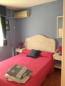 a bedroom with a red bed with a red blanket at Apartment Martinez Casablanca in Alcossebre