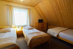 ゾンプにあるPokoje u Rumcajsaのベッド2台と窓が備わる客室です。