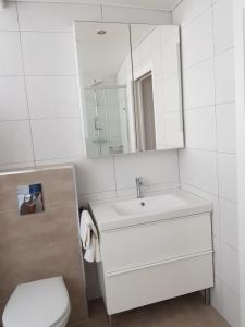 a bathroom with a sink and a toilet and a mirror at Exclusive Apartment - Playa de Marenys de Rafalcaid in Gandía
